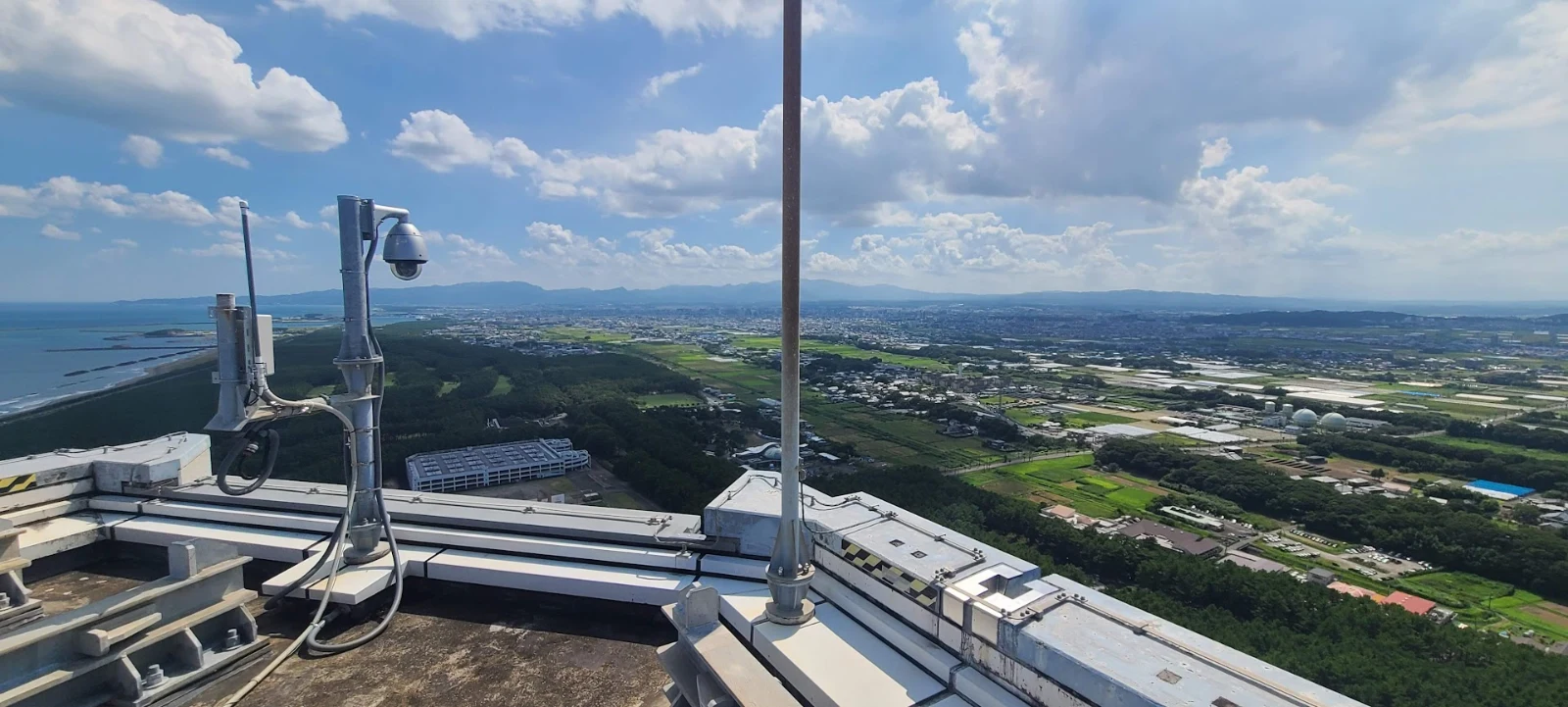 Gateway on the very edge of a very tall building overlooking flat land.